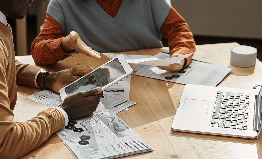 Especialistas. Duas pessoas em uma mesa de reunião conversando.