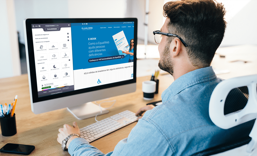 Homem a utilizar um computador com o site da EqualWeb aberto, mostrando ferramentas de acessibilidade digital no ecrã.